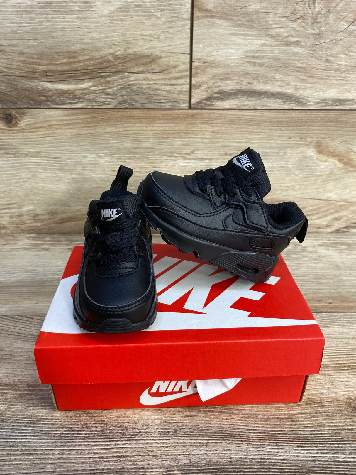 Three-quarter view of Nike Air Max 90 EasyOn toddler sneakers size 4C in triple black showing Air Max sole on red Nike box