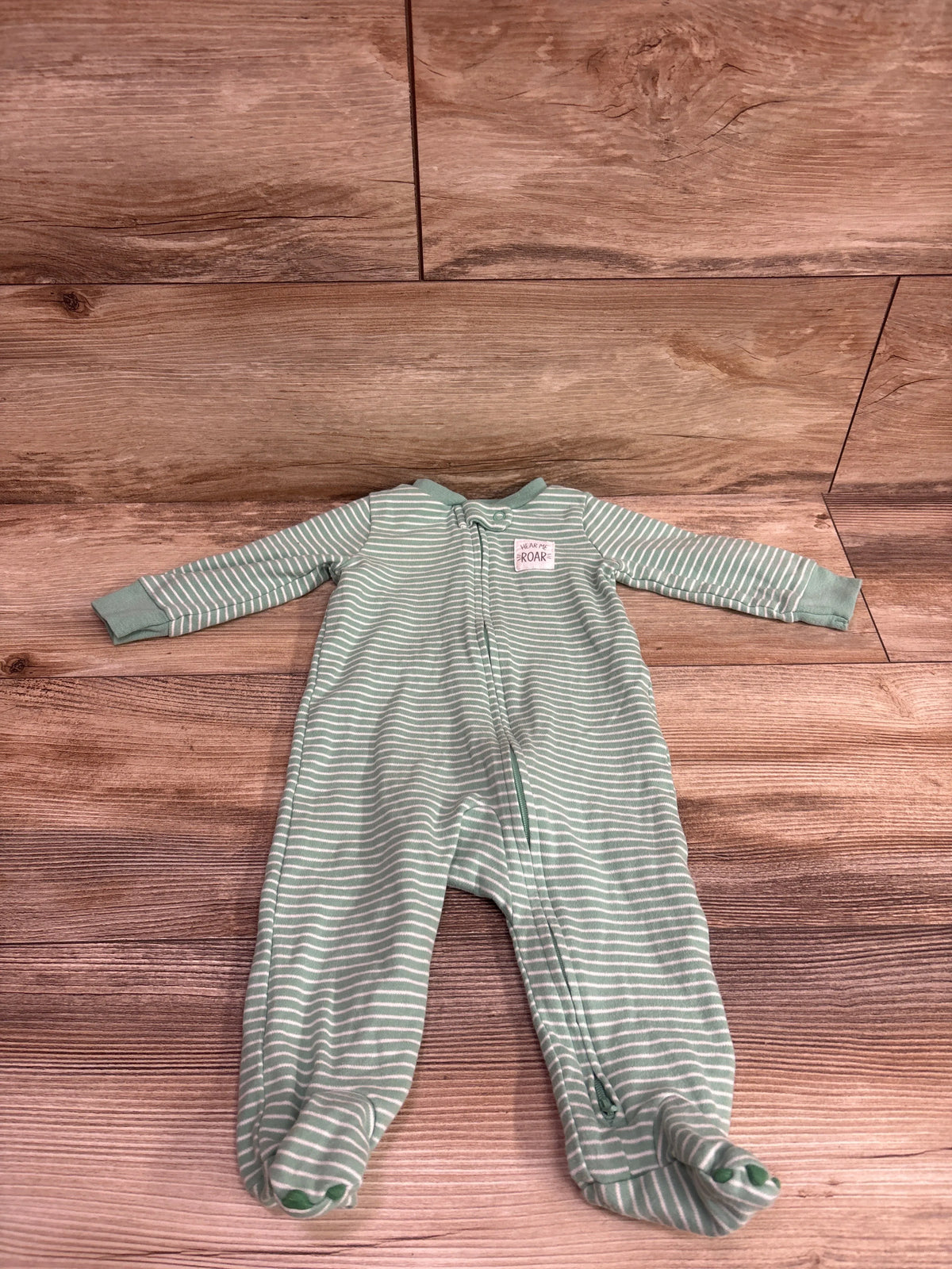 Simple Joys green and white striped baby sleeper for 3-6 months on a wooden background