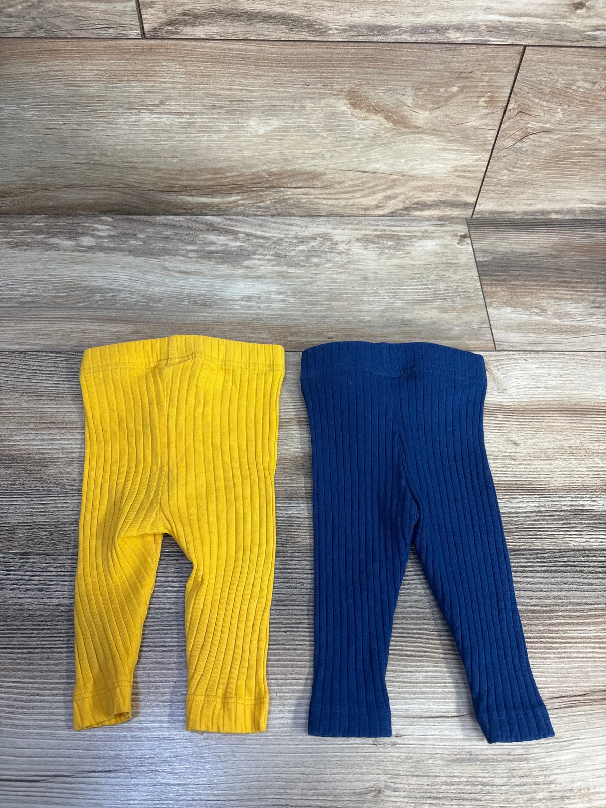 Overhead view of Koala Baby navy ribbed pants two-pack on a wood-look floor