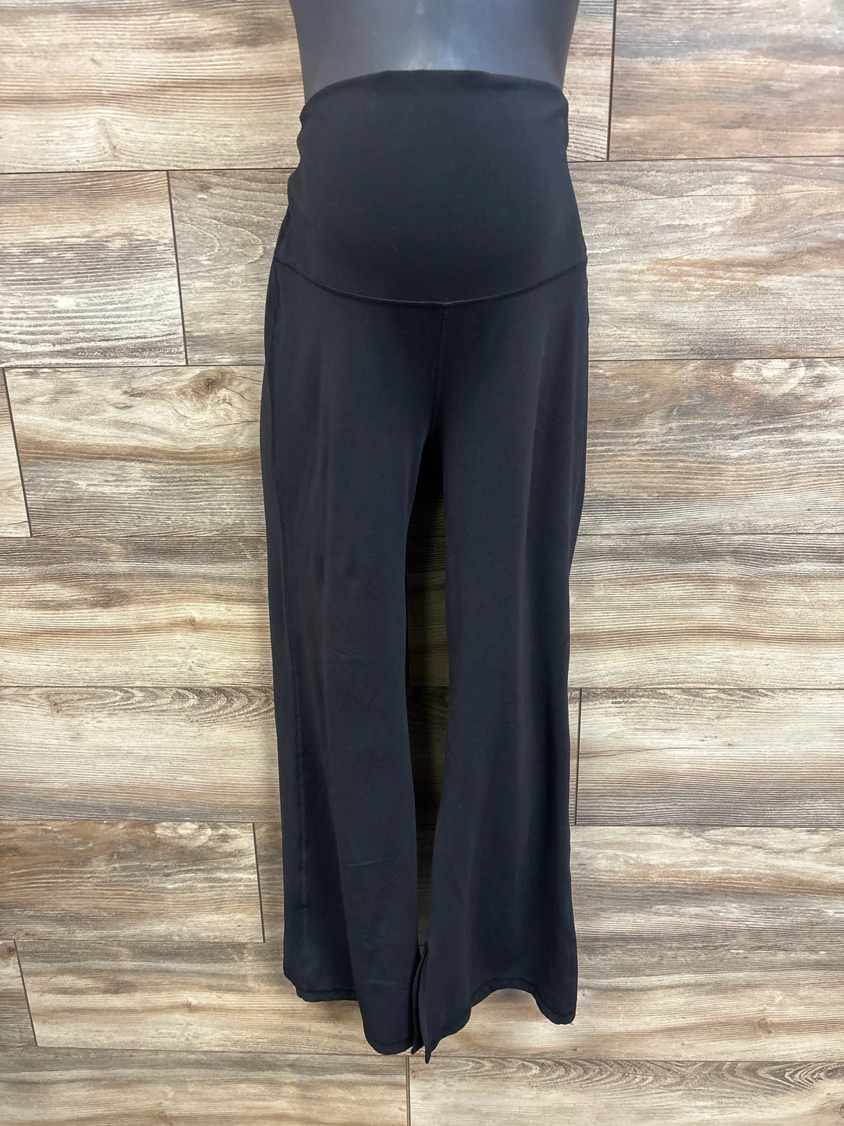 Front view of Isabel maternity leggings showcasing high-rise pregnancy panel and wide-leg silhouette with wood plank background