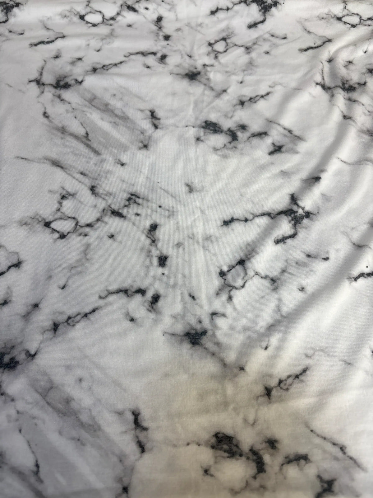 Close-up of Copper Pearl Knit Swaddle Blanket Marble White showcasing black marble print and soft knit texture