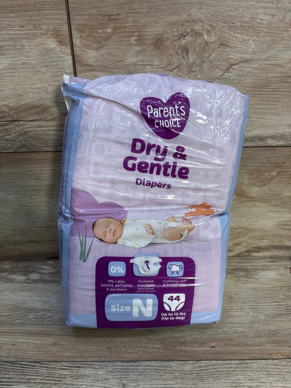 Front view of Parent’s Choice Dry & Gentle newborn diapers showcasing soft breathable design and 44-count pack on a wood floor