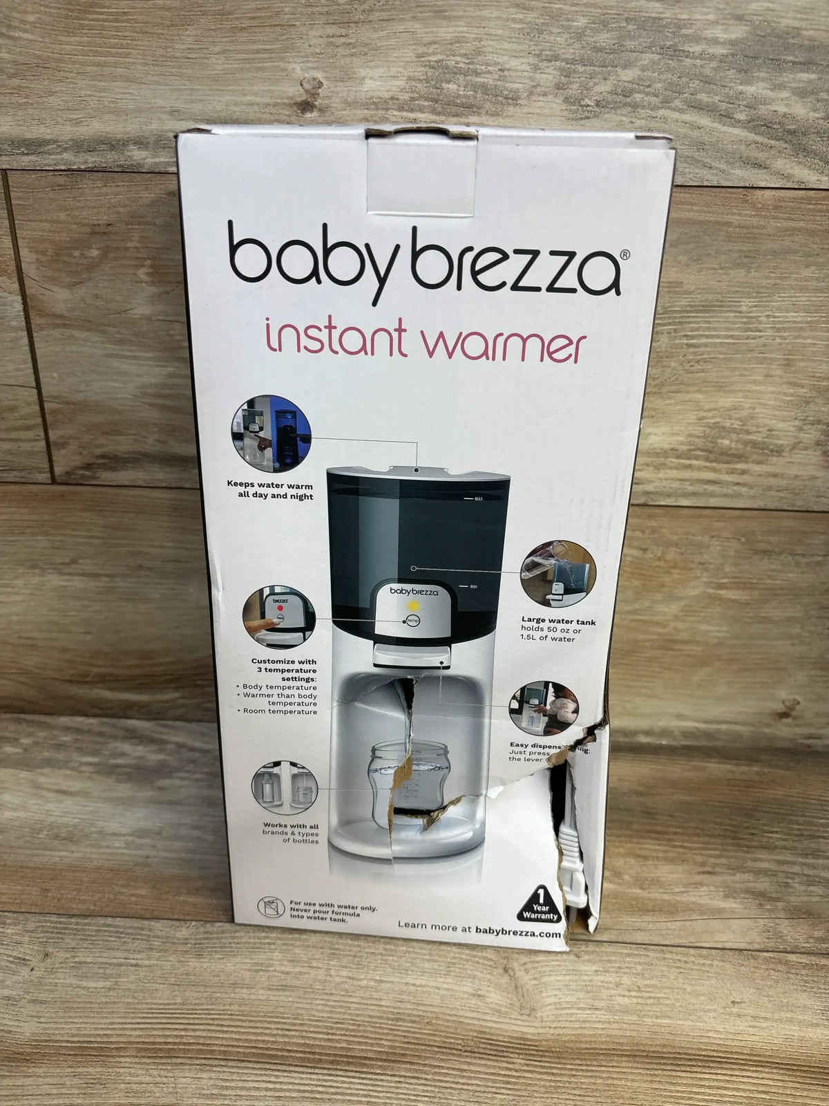 Front view of Baby Brezza Instant Baby Bottle Warmer box with product photo, temperature settings, and water tank callouts