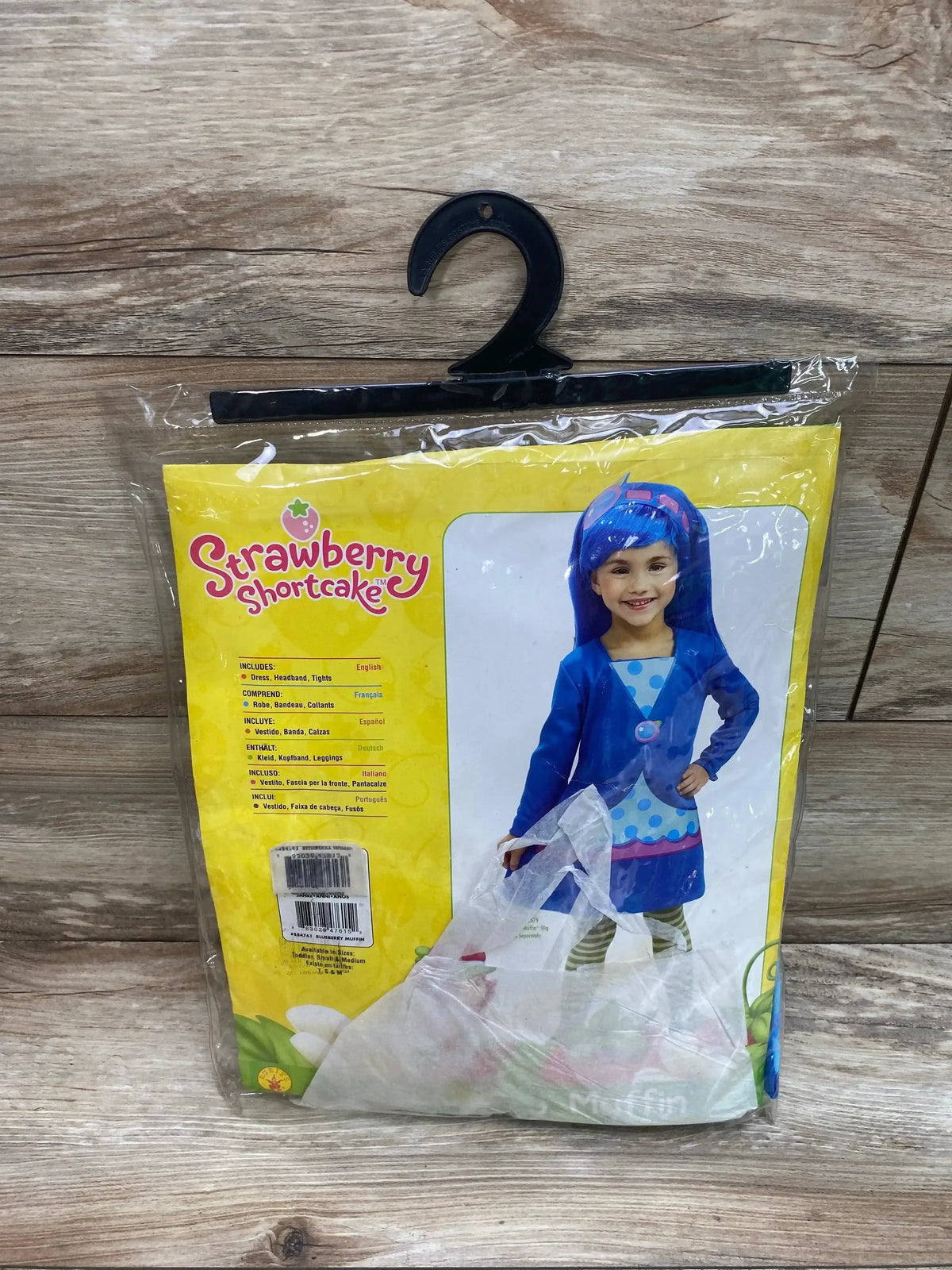 Front view of Rubie’s Blueberry Muffin costume showcasing a blue dress, headband, and tights in packaging