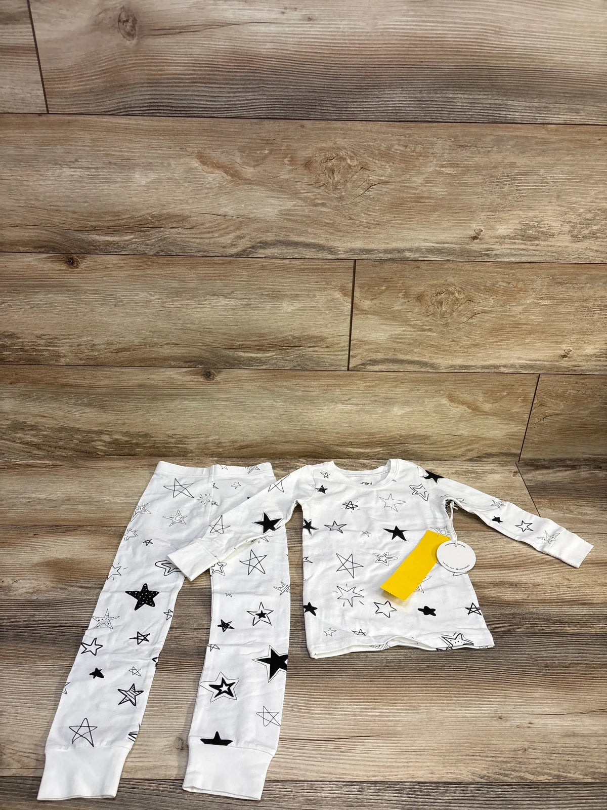 Norani Baby organic pajama set in white with black star print, including top and pants.