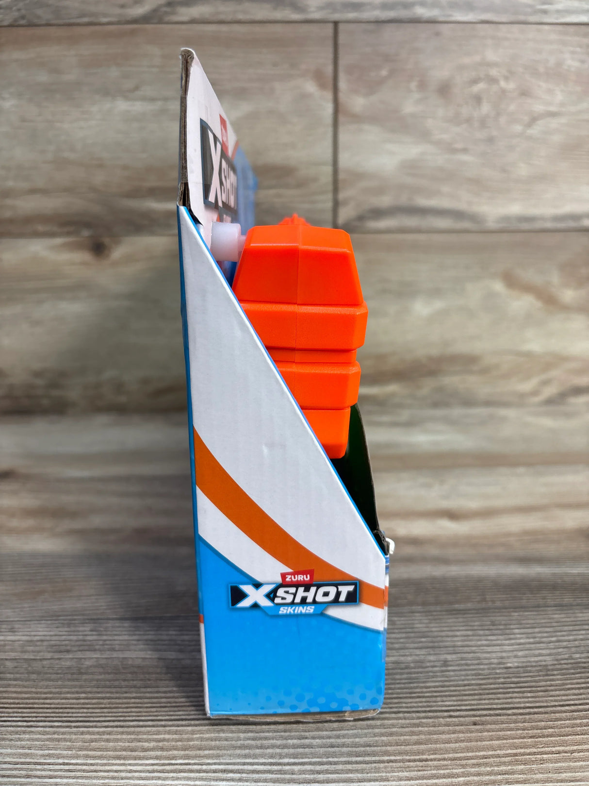 Zuru X-Shot Skins toy blaster in packaging on wood background