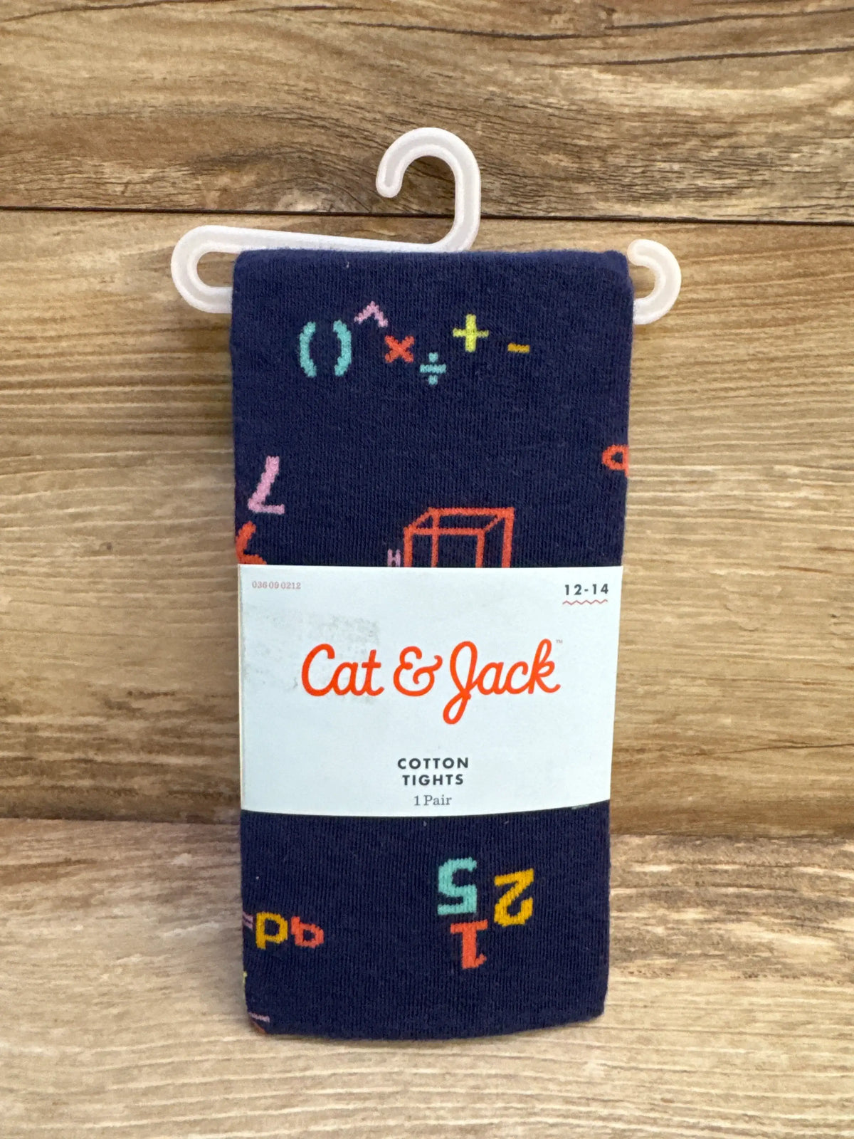 Folded Cat & Jack navy cotton tights with multicolor math print, white label shows size 12-14 on wood background