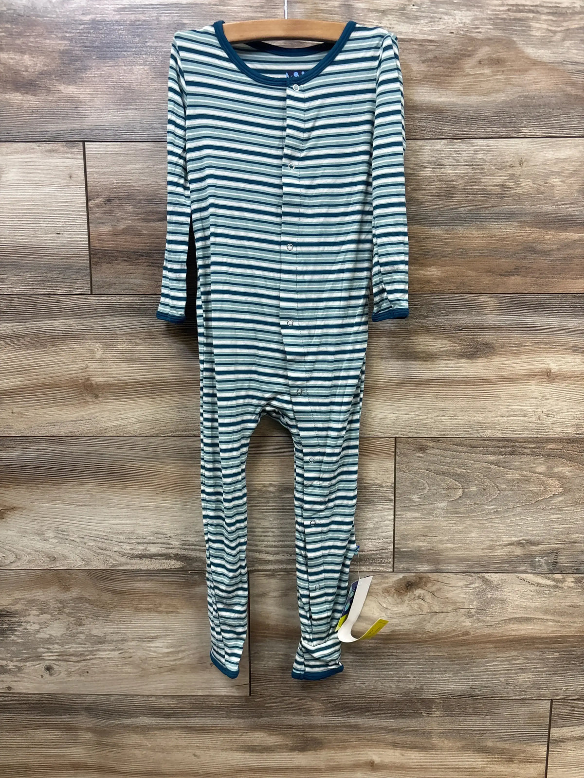 Blue and white striped long sleeve baby sleeper with snap buttons on wooden background