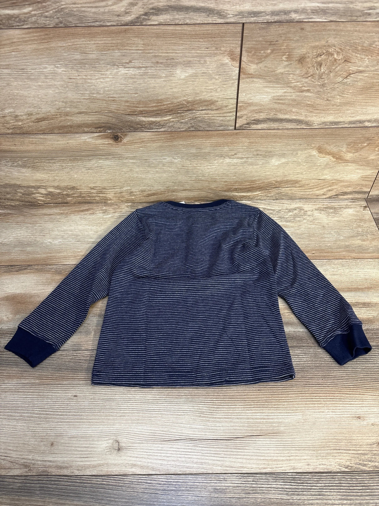 Navy blue long sleeve striped kids shirt on wooden floor