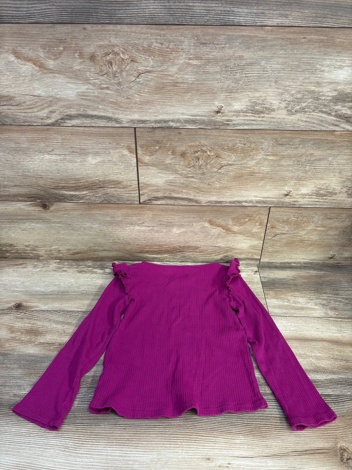 Flat lay of Jumping Beans purple ribbed long-sleeve toddler shirt (5T) showing ruffle shoulder detail on wood background