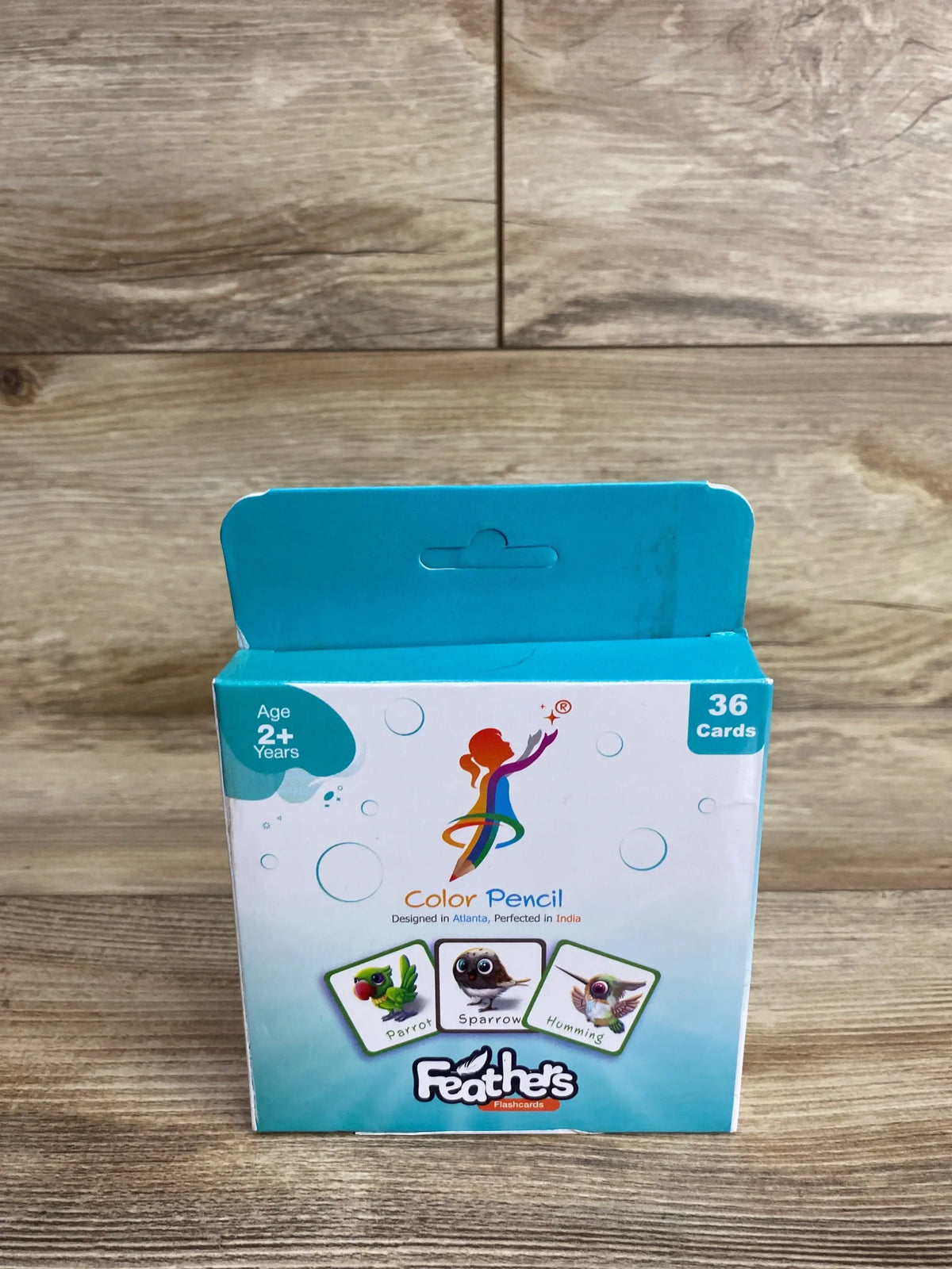 Front view of Color Pencil Feathers flashcards box showing 36 cards and Age 2+ Years label on wood background