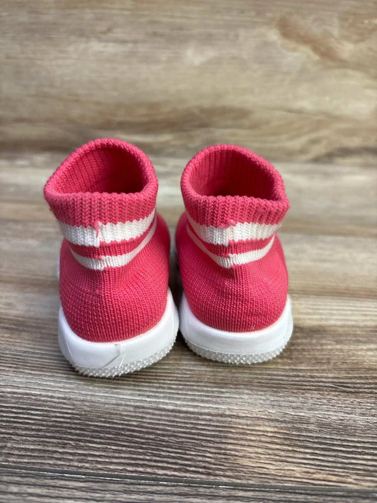 Rear view of Engtoy sock shoes showcasing pink knit uppers, striped ankle cuffs, and white soles on a wood surface