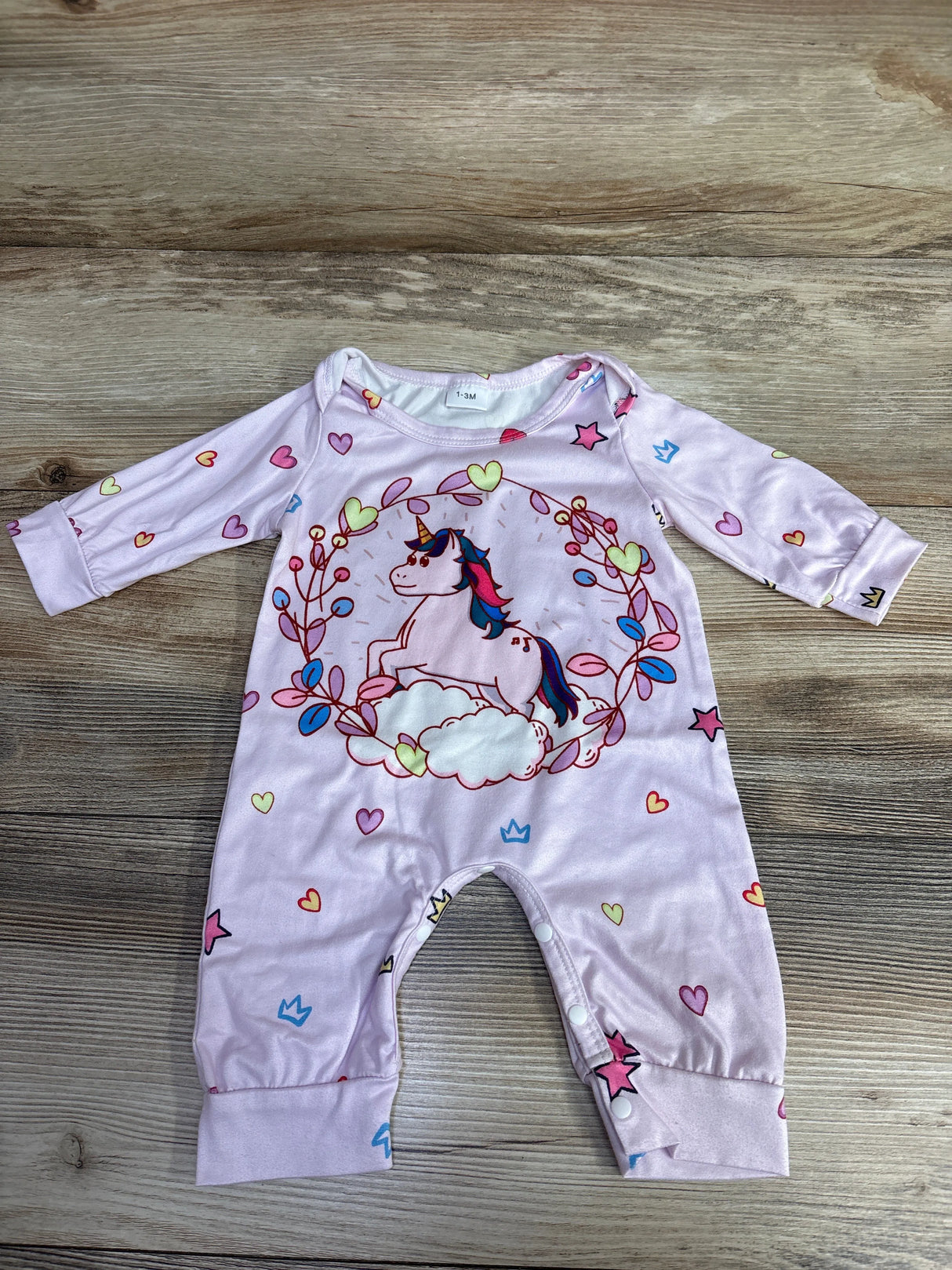Light purple baby onesie with unicorn and heart prints on wooden background, size 1-3 months