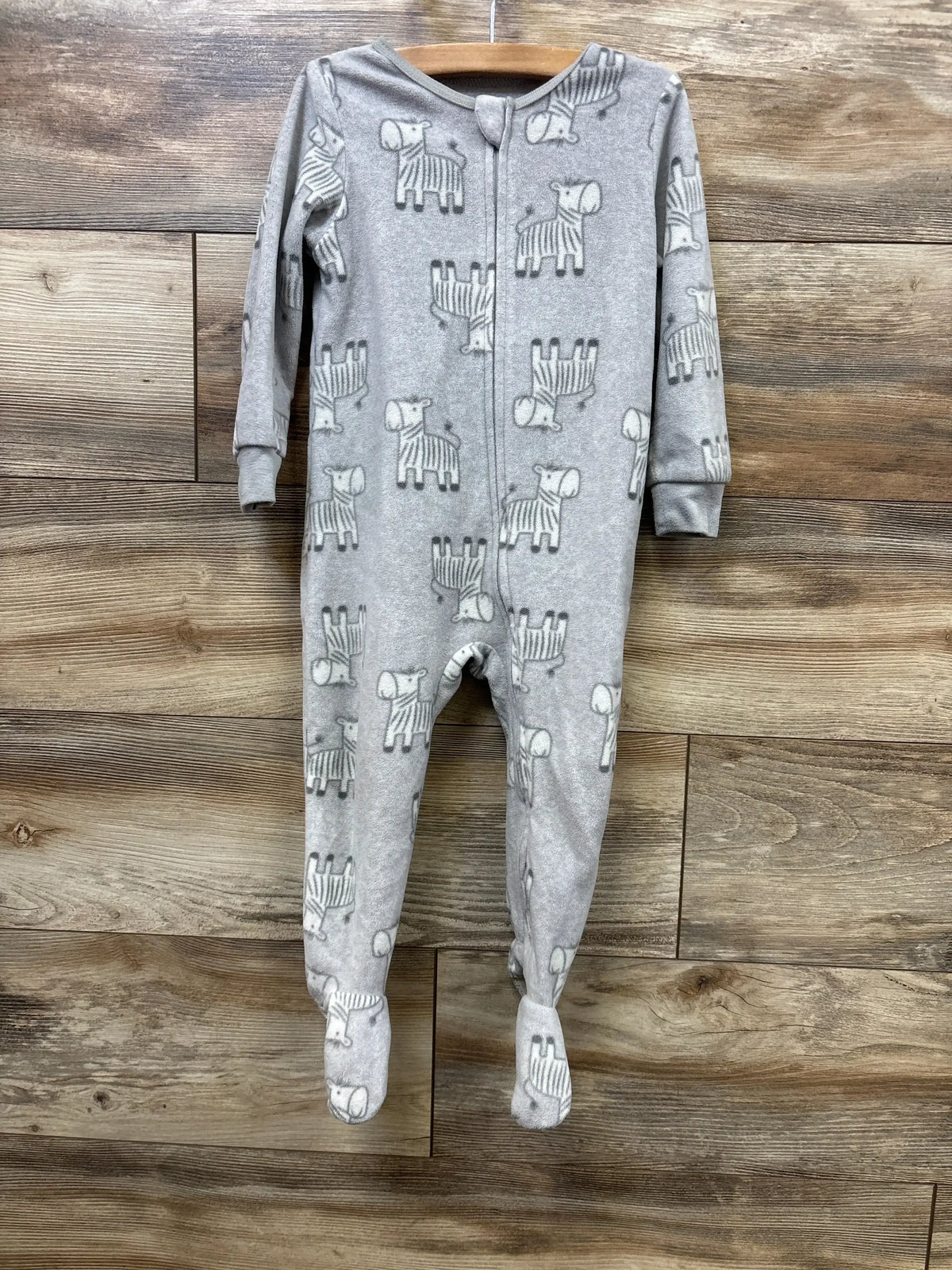 Gray baby footed pajamas with zebra print, long sleeve, zip front, on wooden hanger