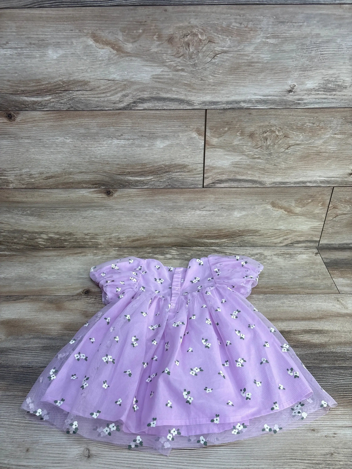 Flat lay of lilac Cat & Jack tulle dress (18 months) showing white daisy embroidery, puff sleeves, and layered skirt on wood background