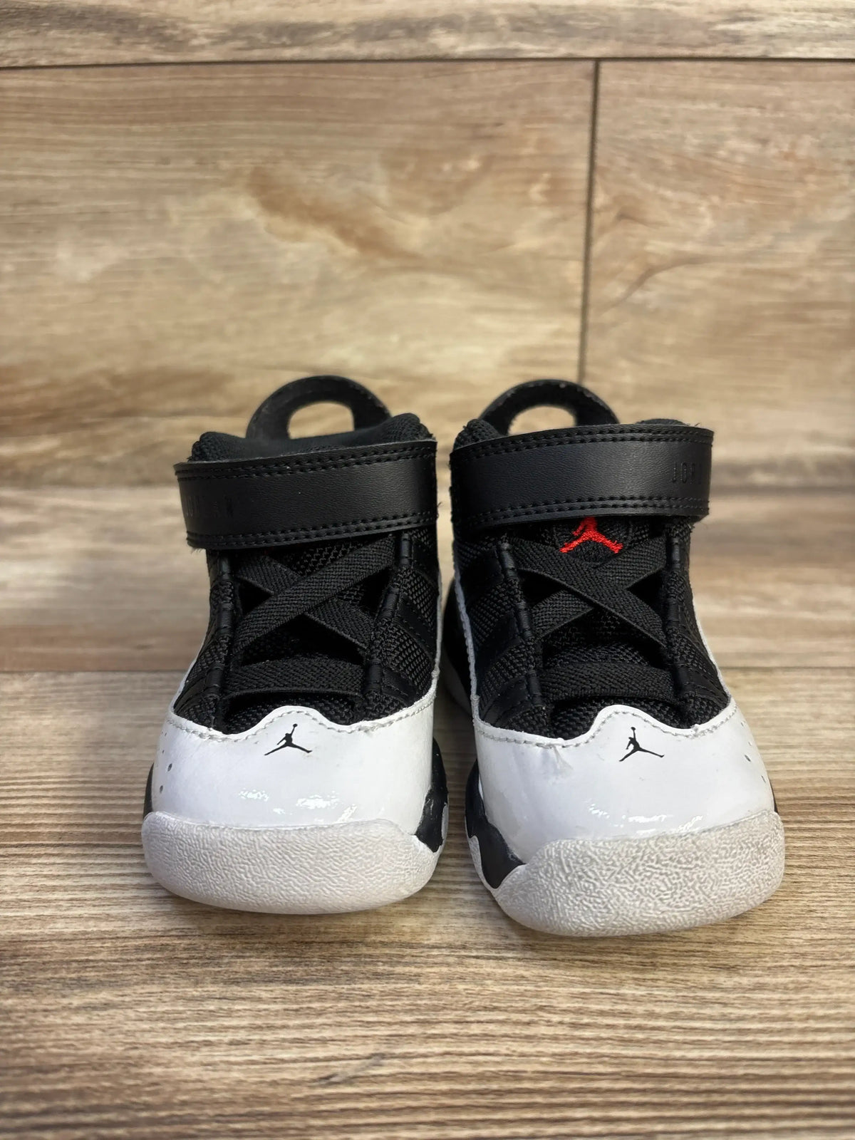 Front view of toddler Air Jordan 6 Rings sneakers, black/white with red Jumpman, Velcro strap and patent-leather toe