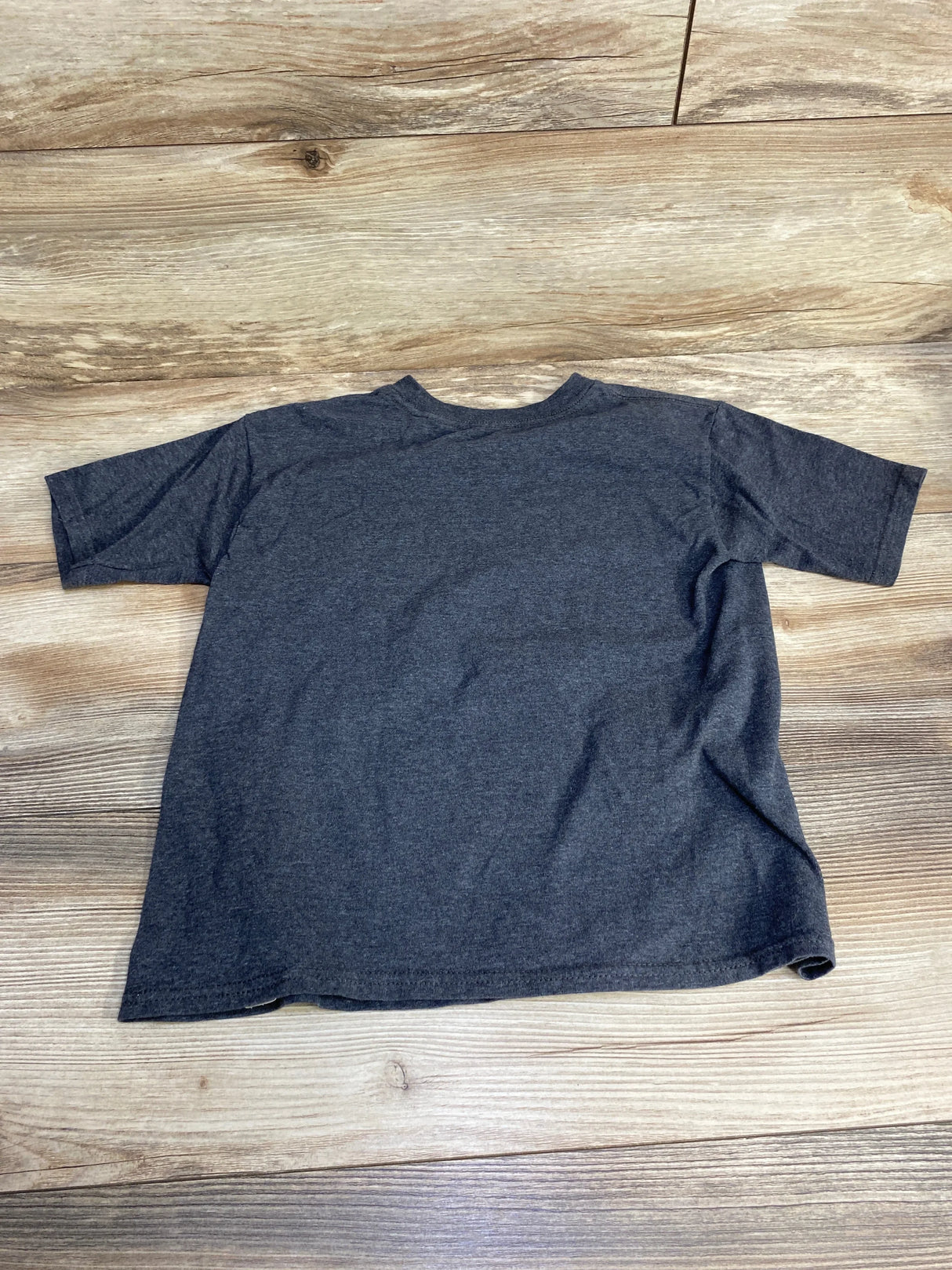 Back view of grey toddler Stranger Things character t-shirt showcasing plain heather back, short sleeves and crew neck on wood floor