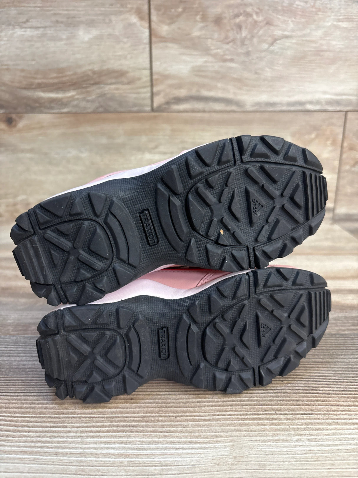 Outsole view of Adidas TERREX Hyperhiker Mid kids mauve sneakers, size 11C, showcasing black rubber lugged tread on wood background