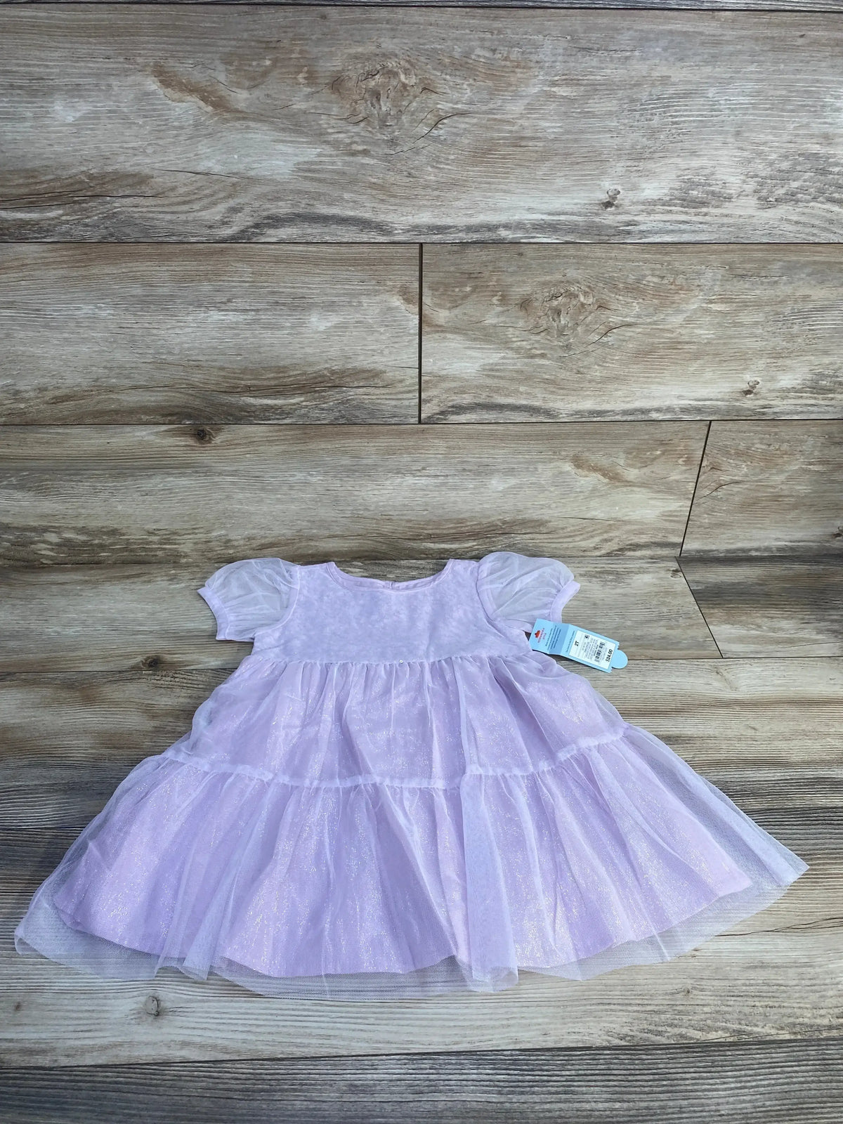 Flat lay of Cat & Jack toddler tulle overlay dress, purple 2T, showing tiered shimmer skirt and puff sleeves on wood