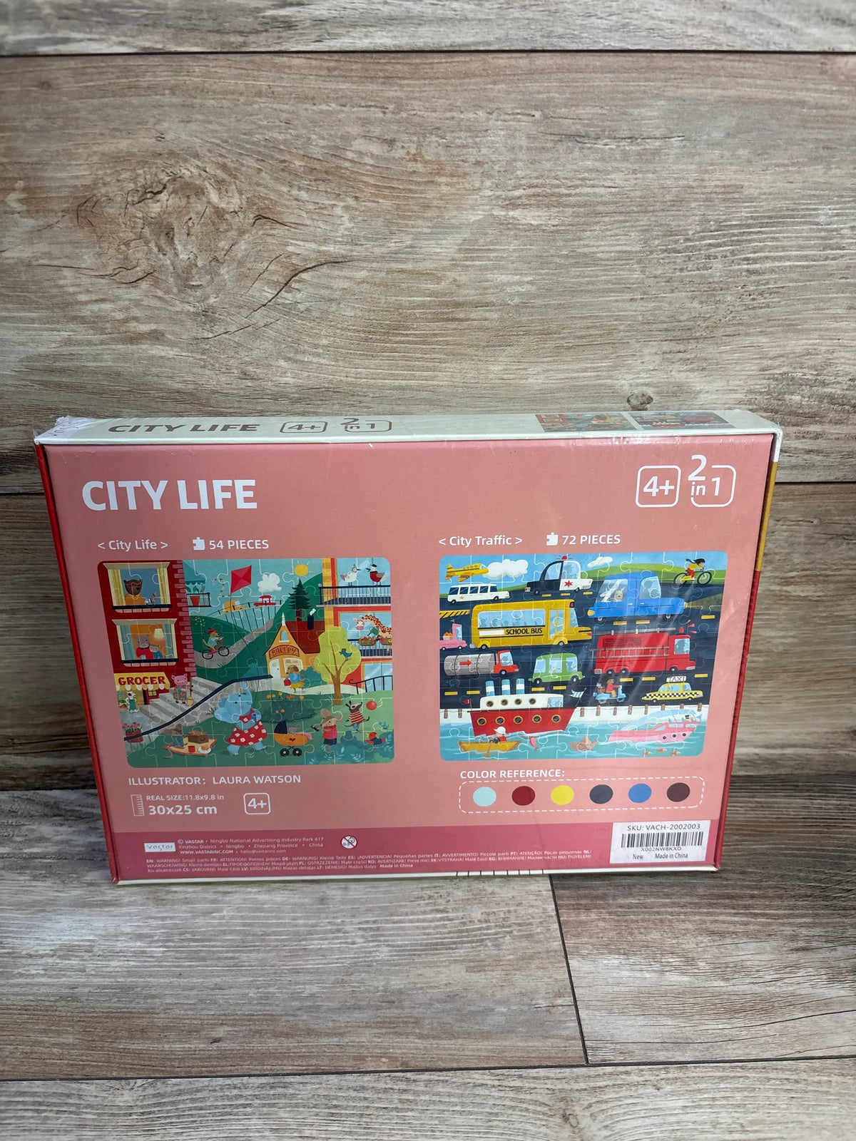 Back of Vastar 2-in-1 City Life puzzle box showing both puzzle illustrations and 54/72 piece counts on a wooden floor background