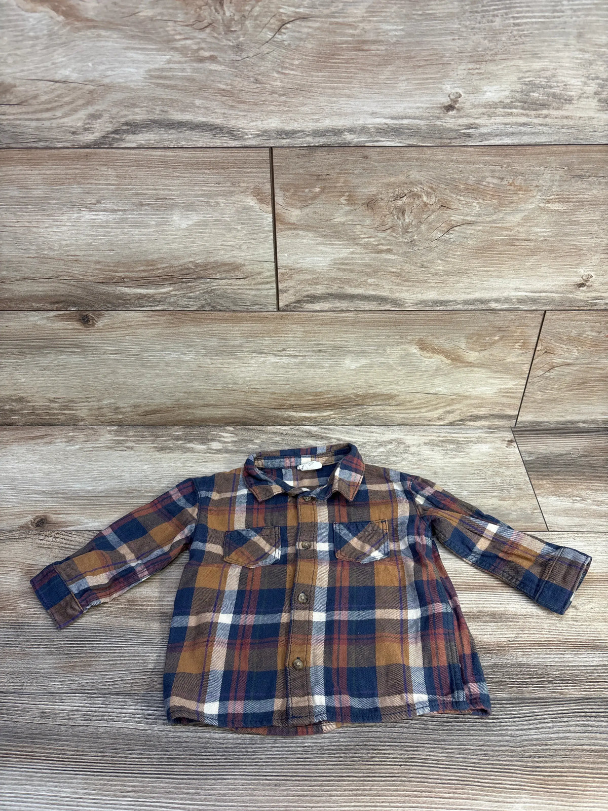 Front view of H&M navy button-up flannel shirt showcasing plaid pattern, long sleeves, collar, buttons, and chest pockets