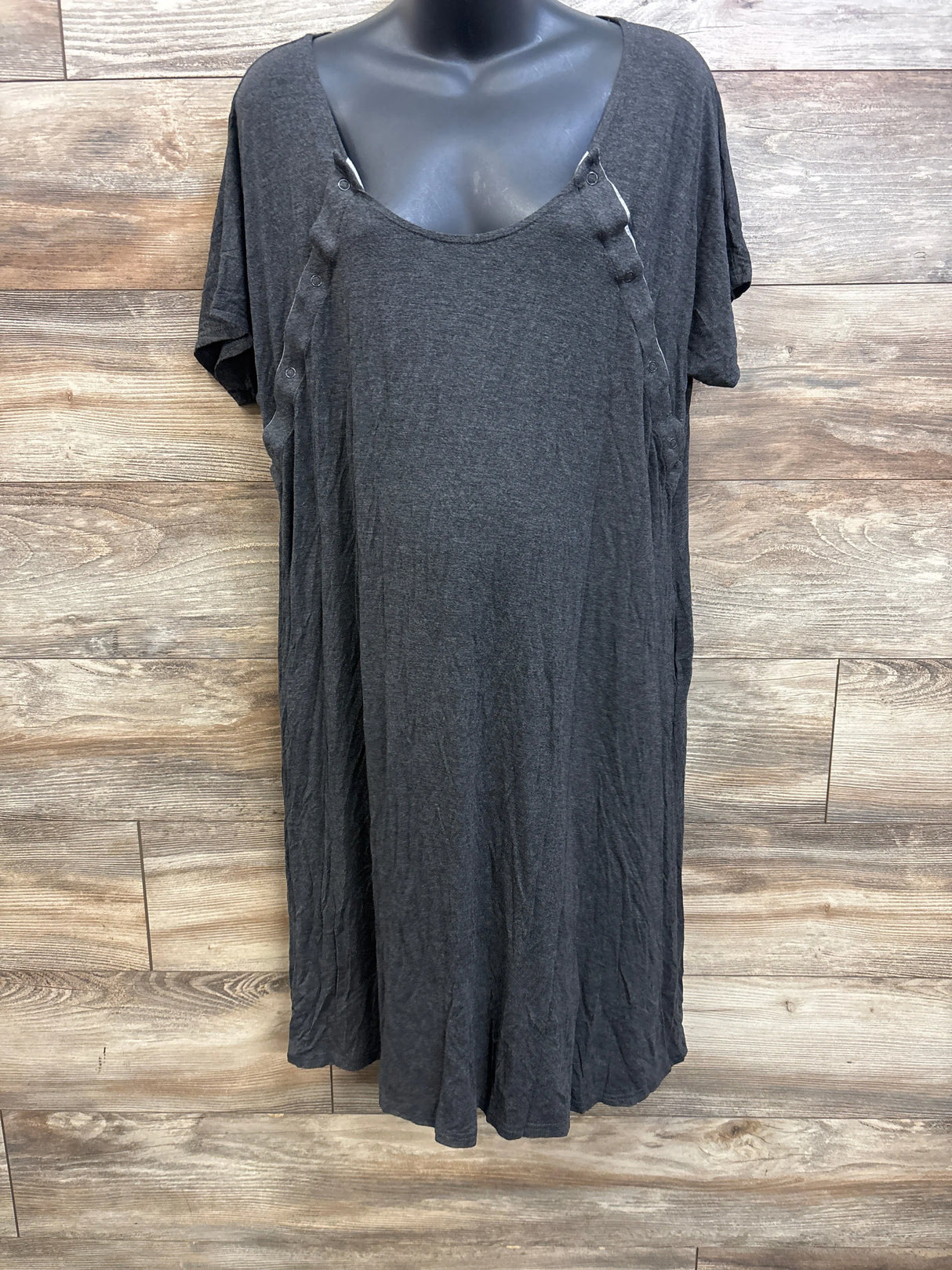 Front view of Frida delivery and nursing gown in grey showing snap button nursing openings and short sleeves on a black mannequin against wood panel background