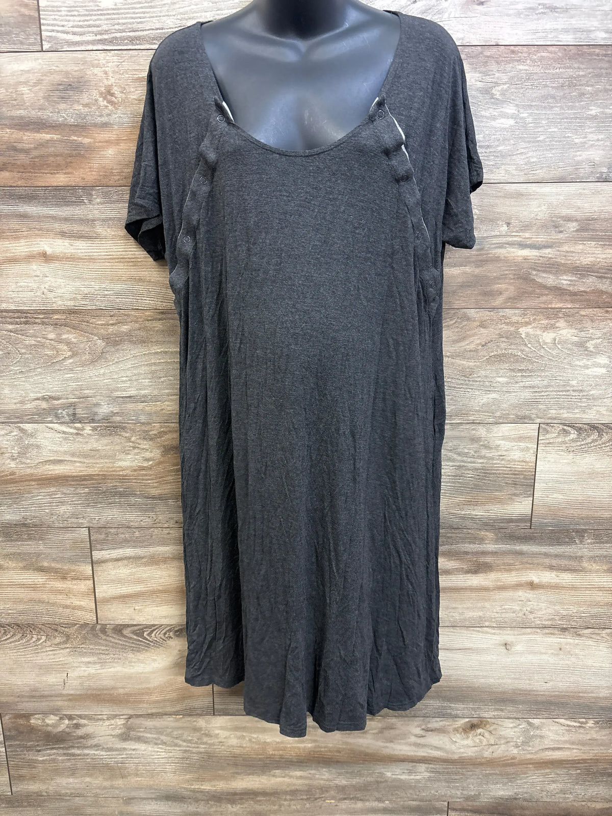 Front view of Frida delivery and nursing gown in grey showing snap button nursing openings and short sleeves on a black mannequin against wood panel background