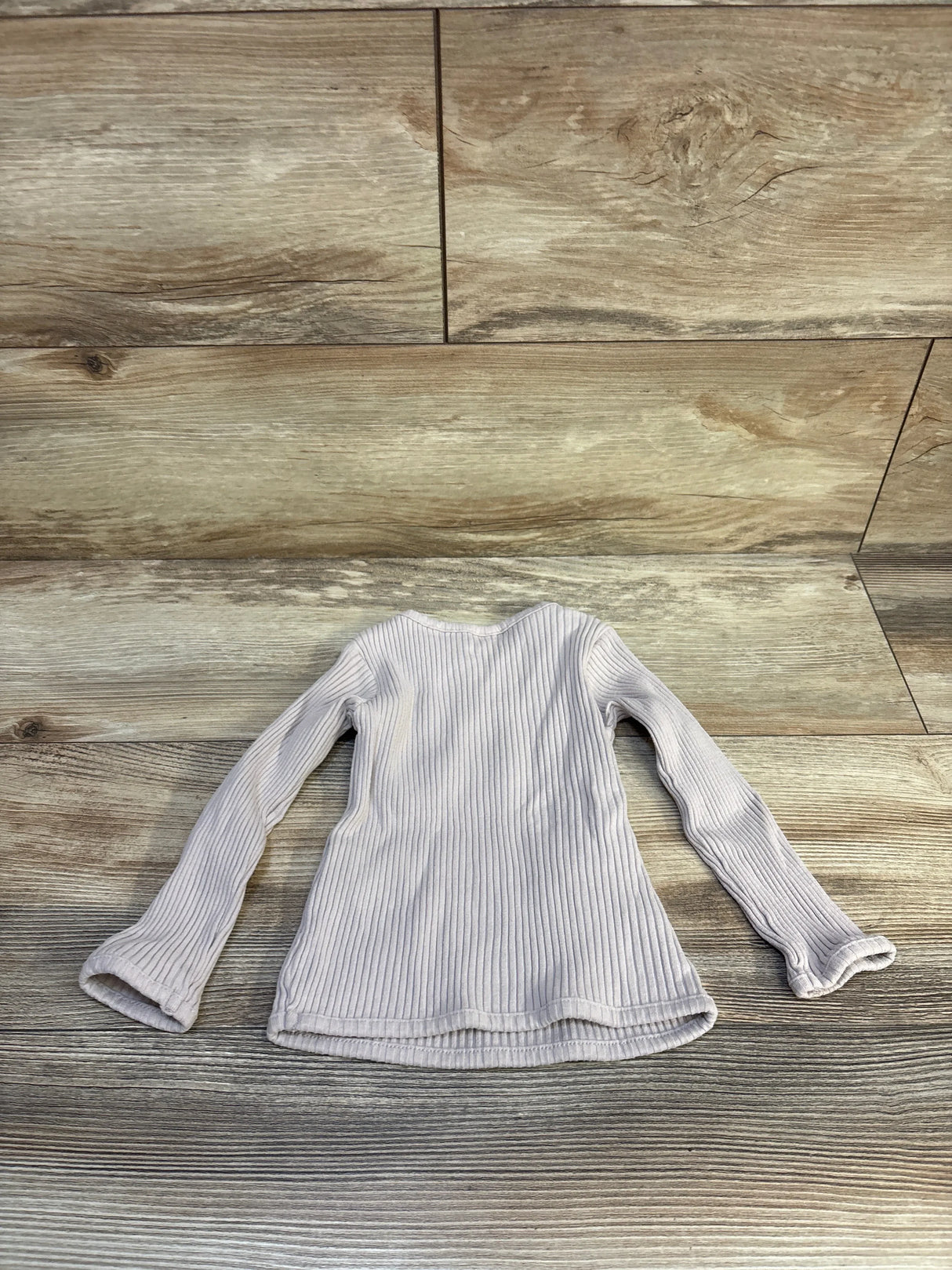 Ribbed long sleeve kids shirt in light beige, displayed on wood background