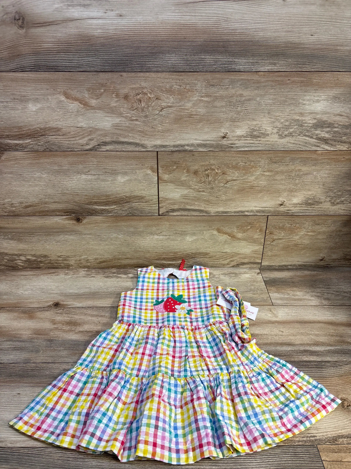 Front view of Bonnie Jean seersucker dress and matching headband with multicolor checked tiers and strawberry applique