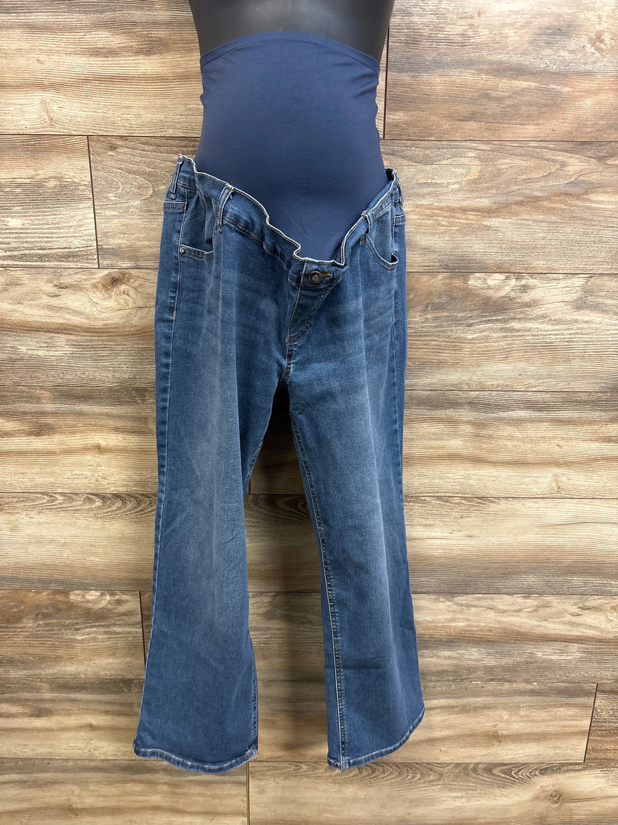 Front view of Time and Tru maternity jeans with navy belly panel and bootcut legs on mannequin against wood background