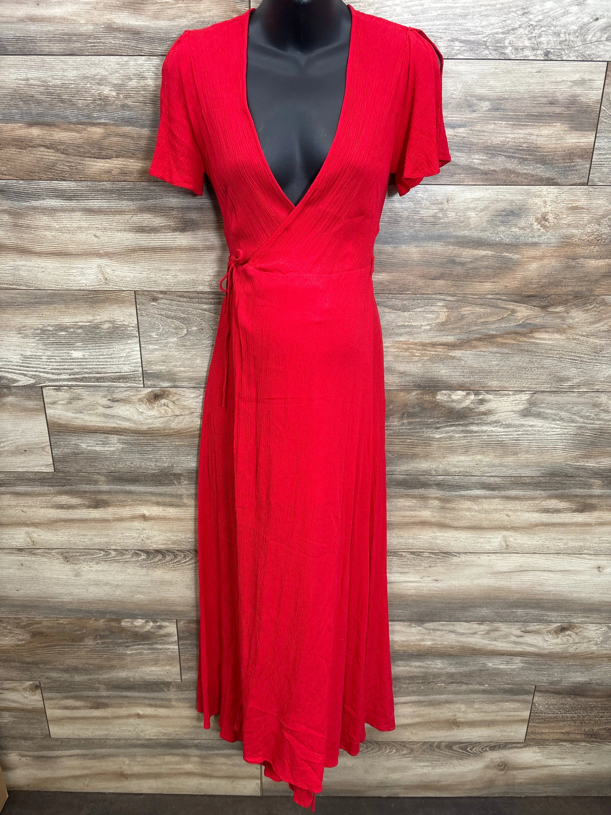 Red short sleeve wrap dress for women on mannequin, deep v-neck, wood background