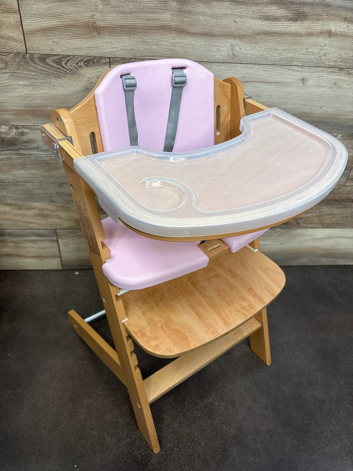 Wooden high chair with pink seat cushion and plastic tray for babies or toddlers