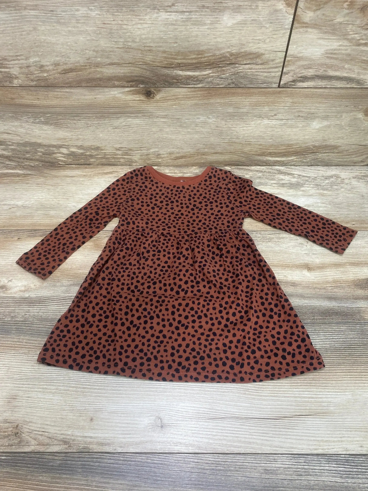 Flat lay of Old Navy toddler cheetah print long-sleeve dress, rust brown with black spots, size 2T on light wood background