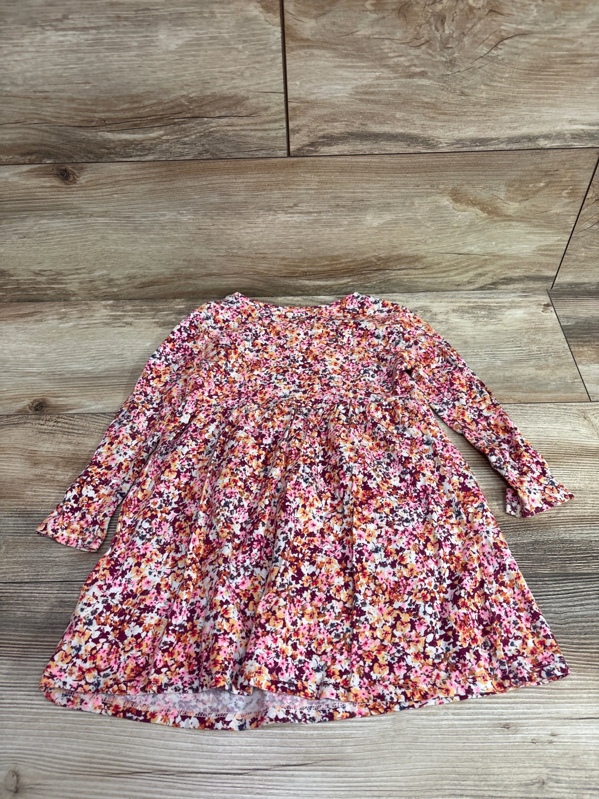 Old Navy floral long sleeve dress for toddlers in red and pink patterns on a wood floor
