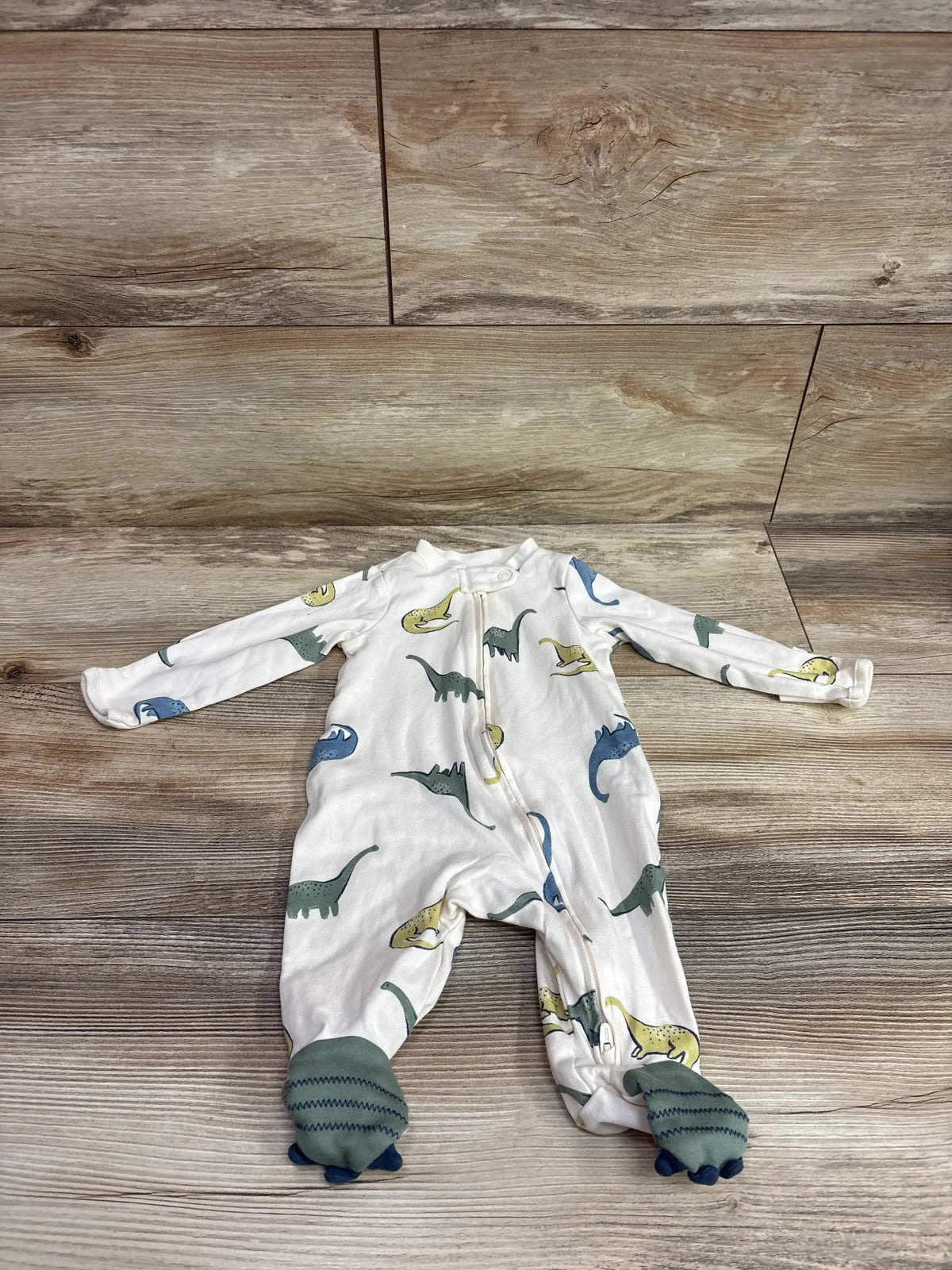 Ivory Child Of Mine infant sleeper with colorful dinosaur print and green footies.