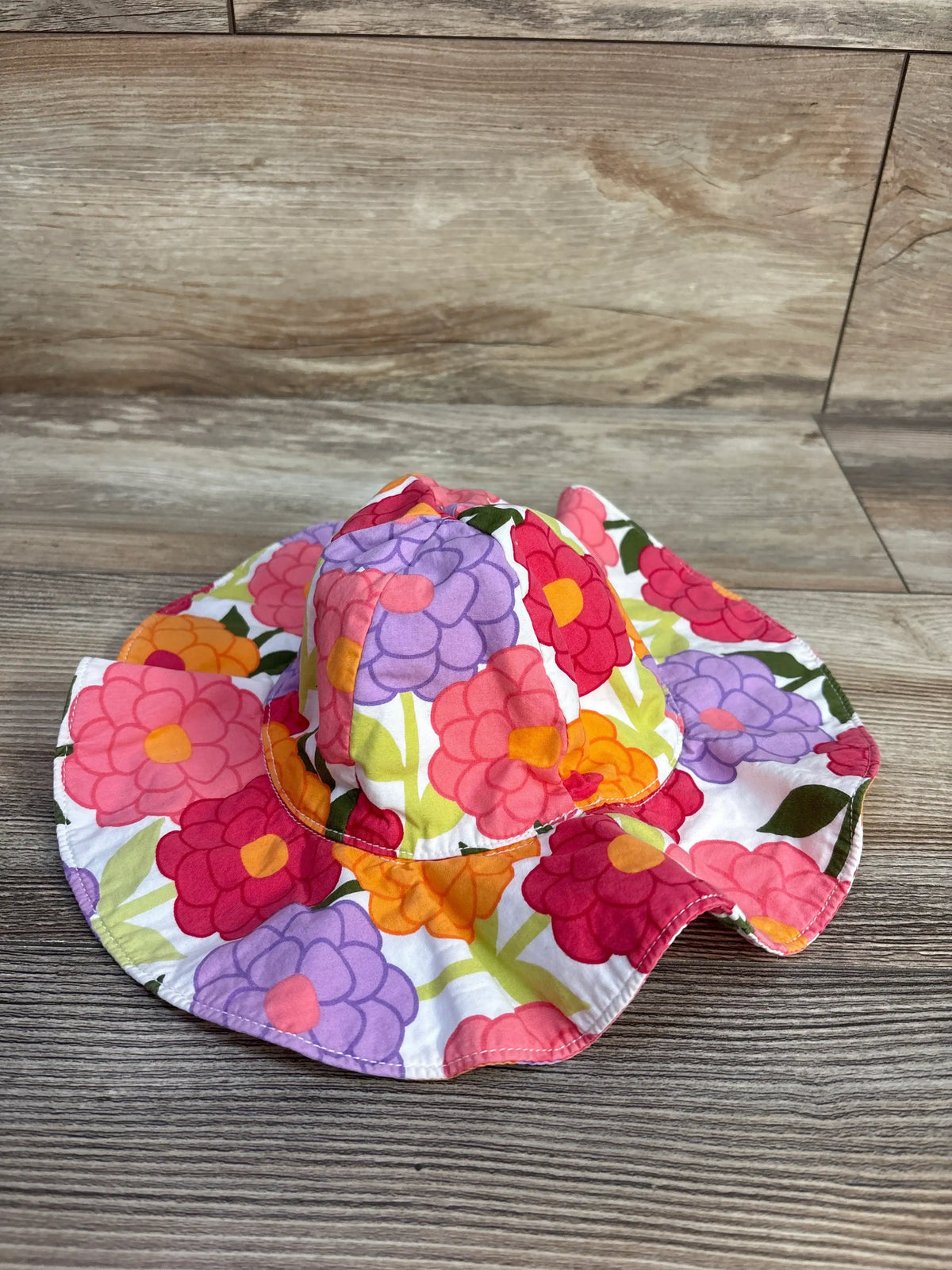 Front view of Gymboree floral bucket hat showcasing a wide brim and colorful flowers on white fabric