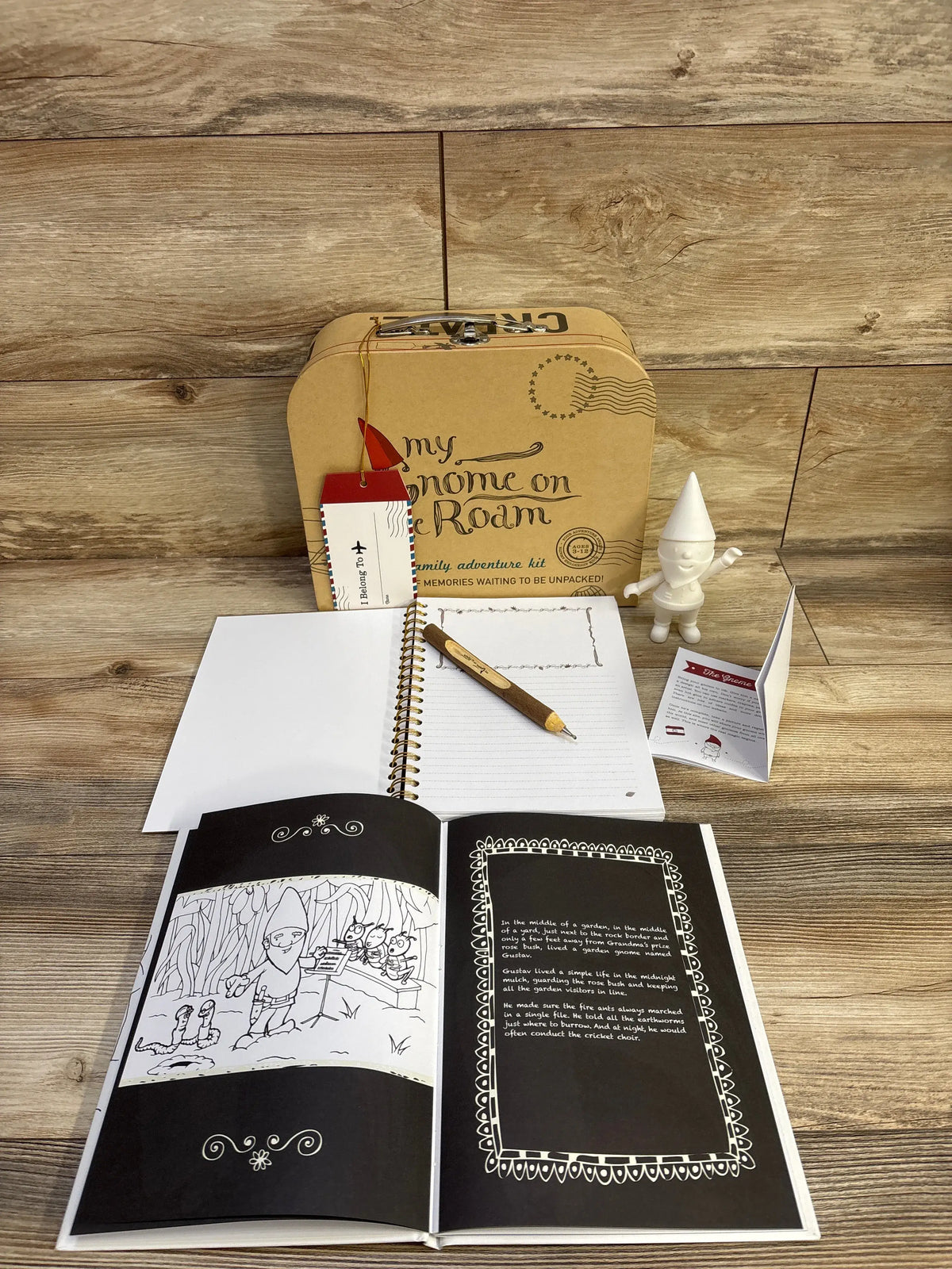 Front view of My Gnome On The Roam Adventure Kit showcasing a gnome, storybook, journal, and wooden pen on a wood floor