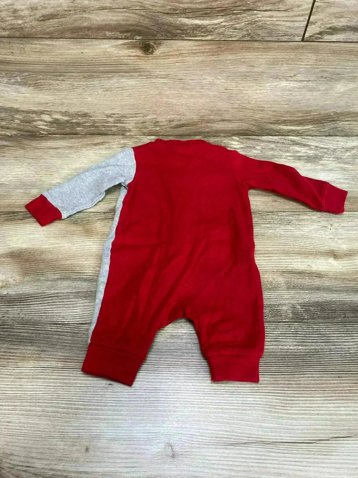 Back view of Tampa Bay NFL coverall 0-3m showing red body, gray left sleeve and side panel, cuffed sleeves and ankles on wood