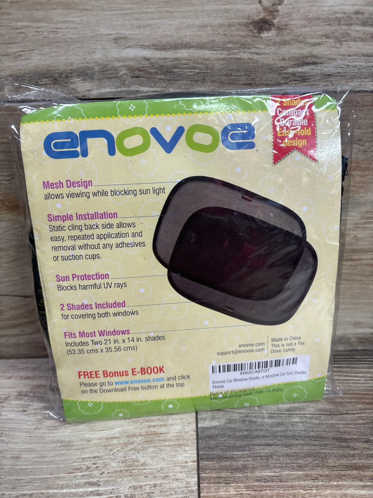 Front view of Enovoe car window shade for baby two pack showcasing black mesh shades in packaging on a wood surface