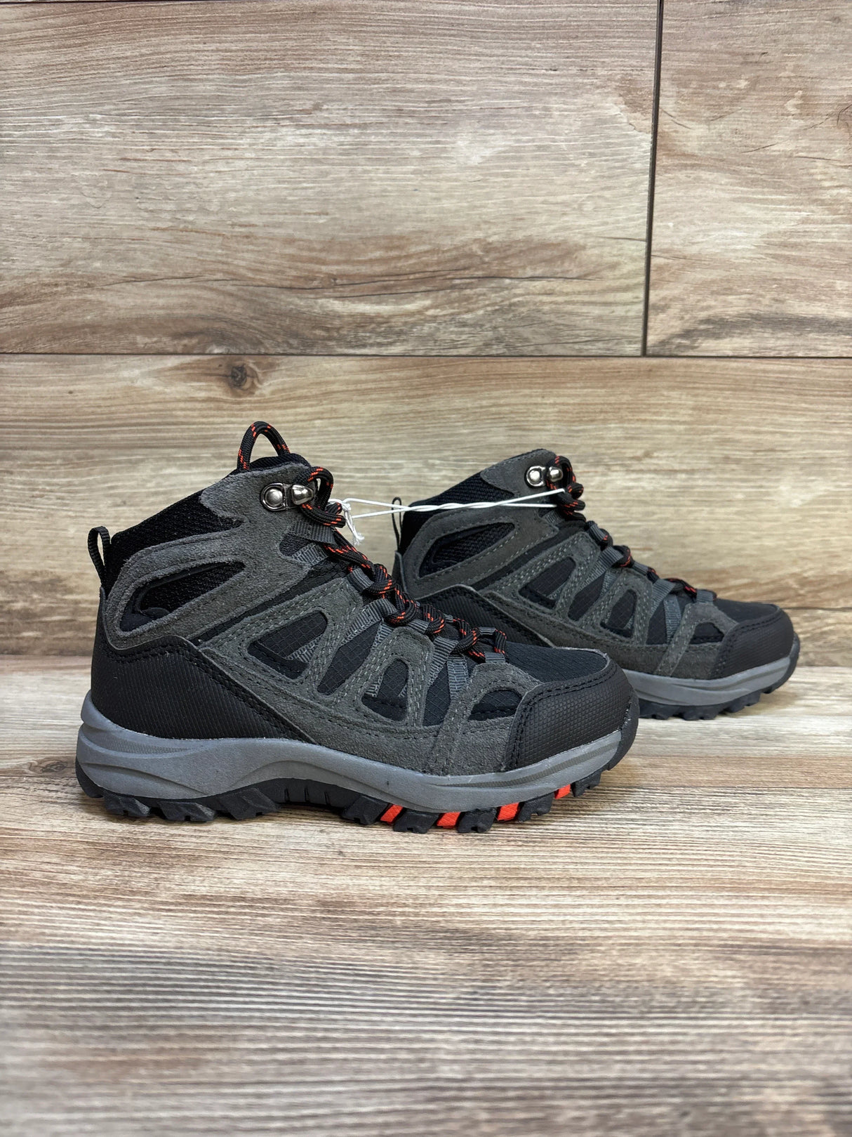 Kids black and gray hiking boots with red accents on wood background