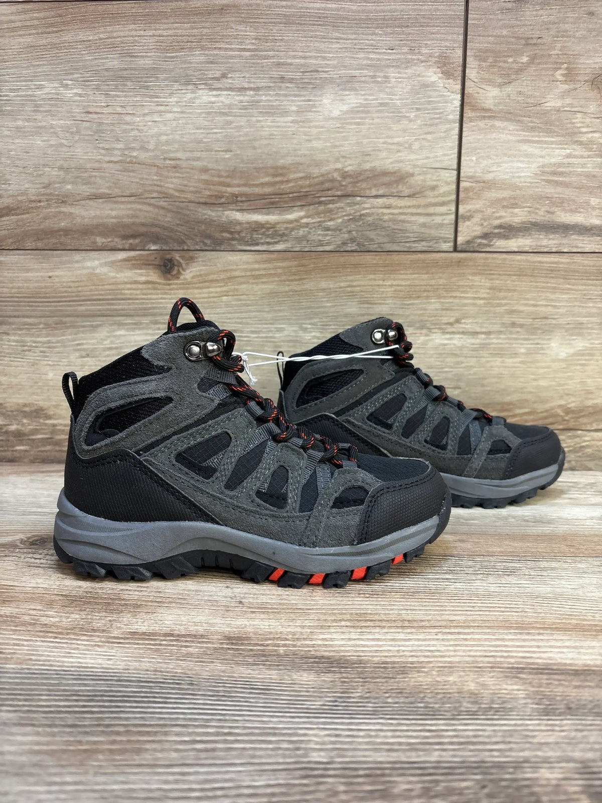 Kids black and gray hiking boots with red accents on wood background