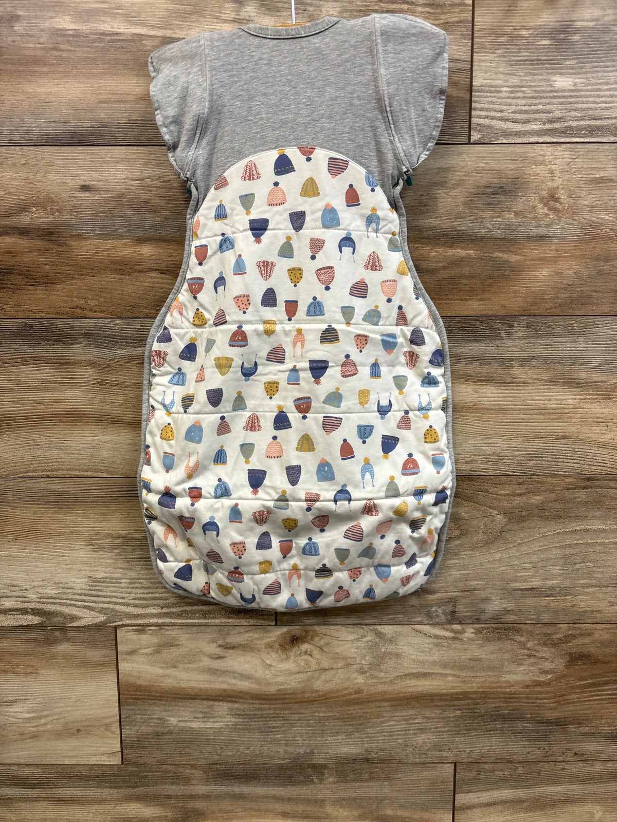 Front flat lay of Love To Dream Swaddle UP bag M (3-6m) showing hat-print front and grey top on wood background