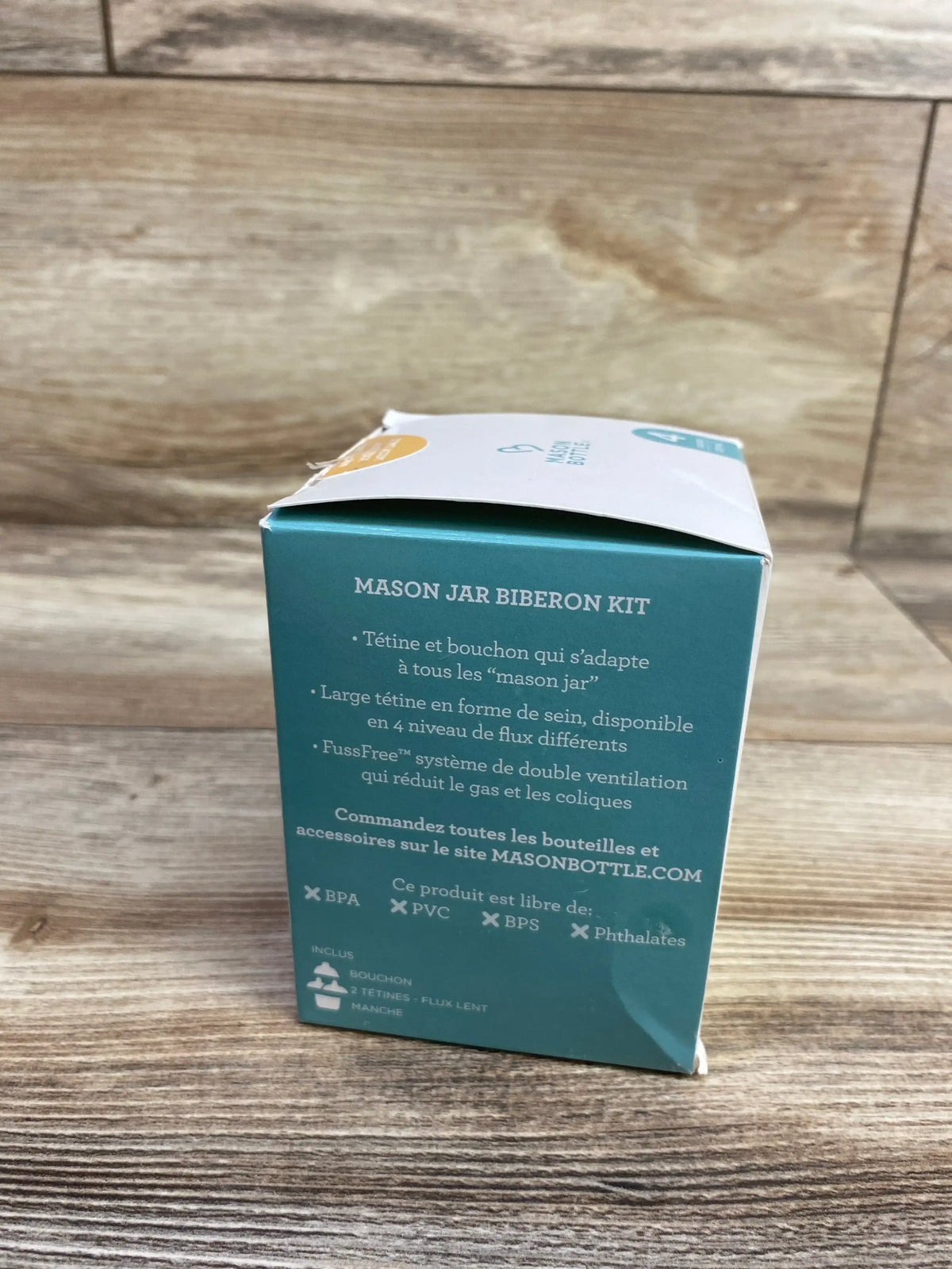 Mason jar baby bottle kit box on wood surface, showing product features and BPA-free label.