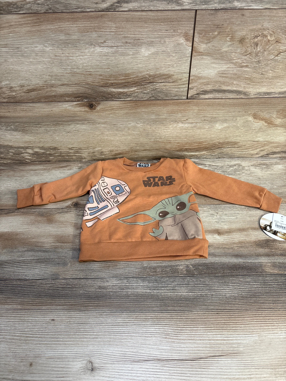 Brown toddler Star Wars sweatshirt with R2-D2 and Baby Yoda on wooden background