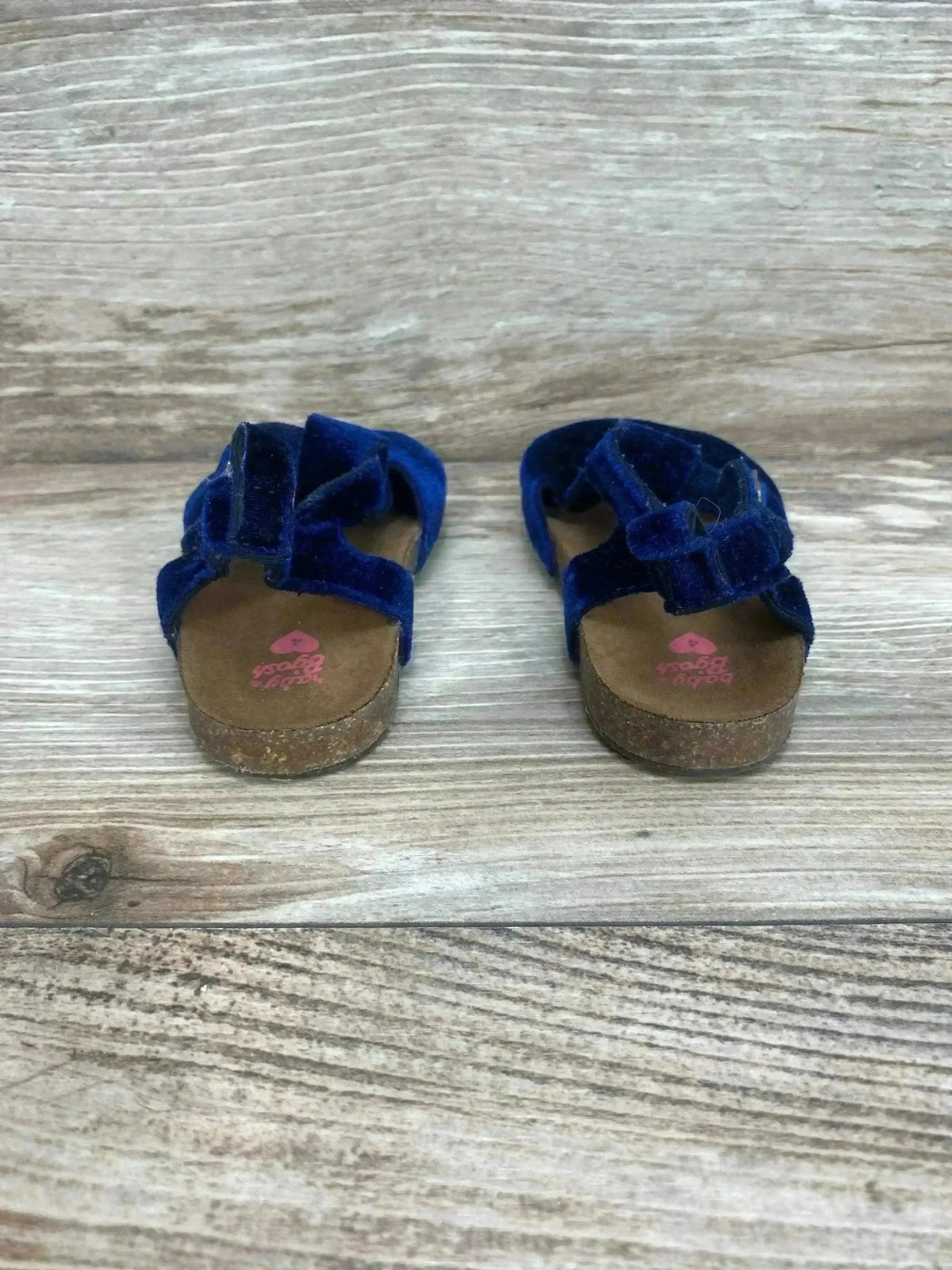 Front view of Baby B’gosh navy velvet baby sandals, size 4C, showing double velcro straps and cork footbed on wood background