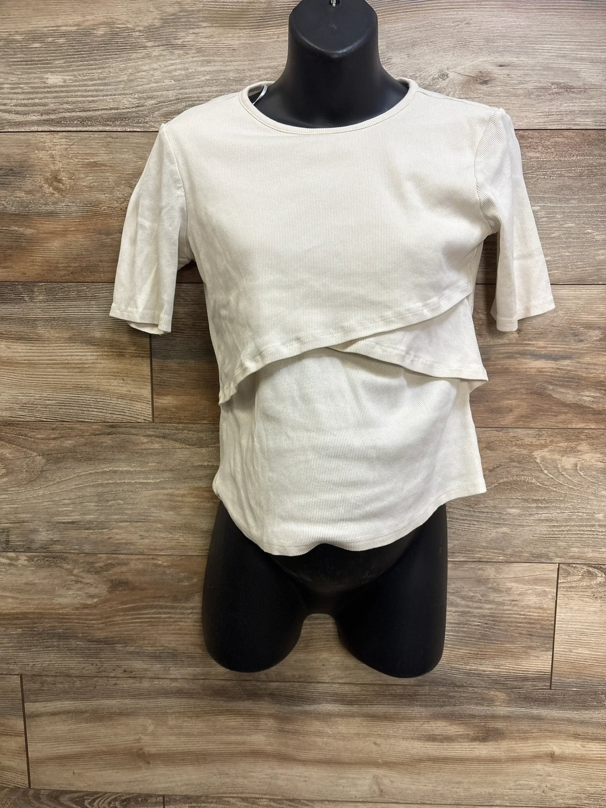 Front view of ivory H&M ribbed nursing shirt with overlapping nursing flap and short sleeves on black mannequin
