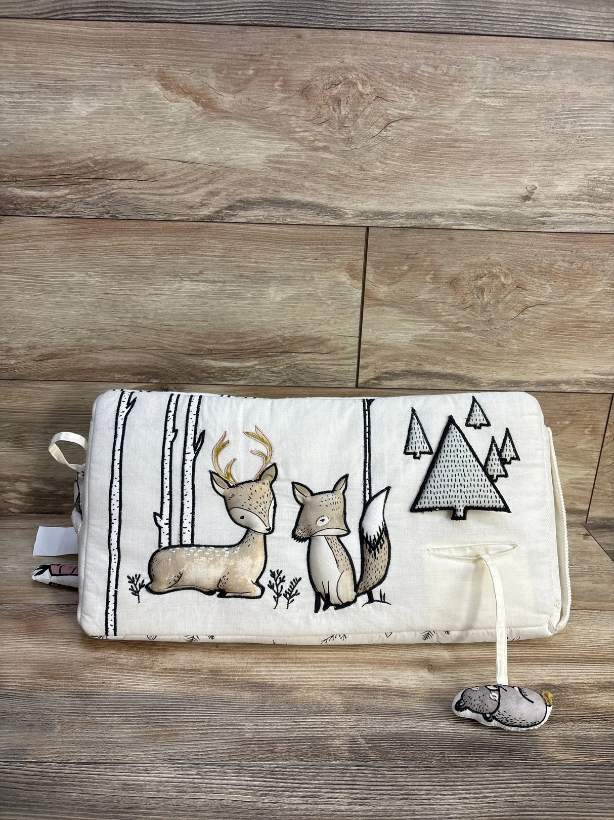Front of Crate & Kids Woodland Animals tummy time toy with embroidered deer and fox and plush pull toy on wood floor