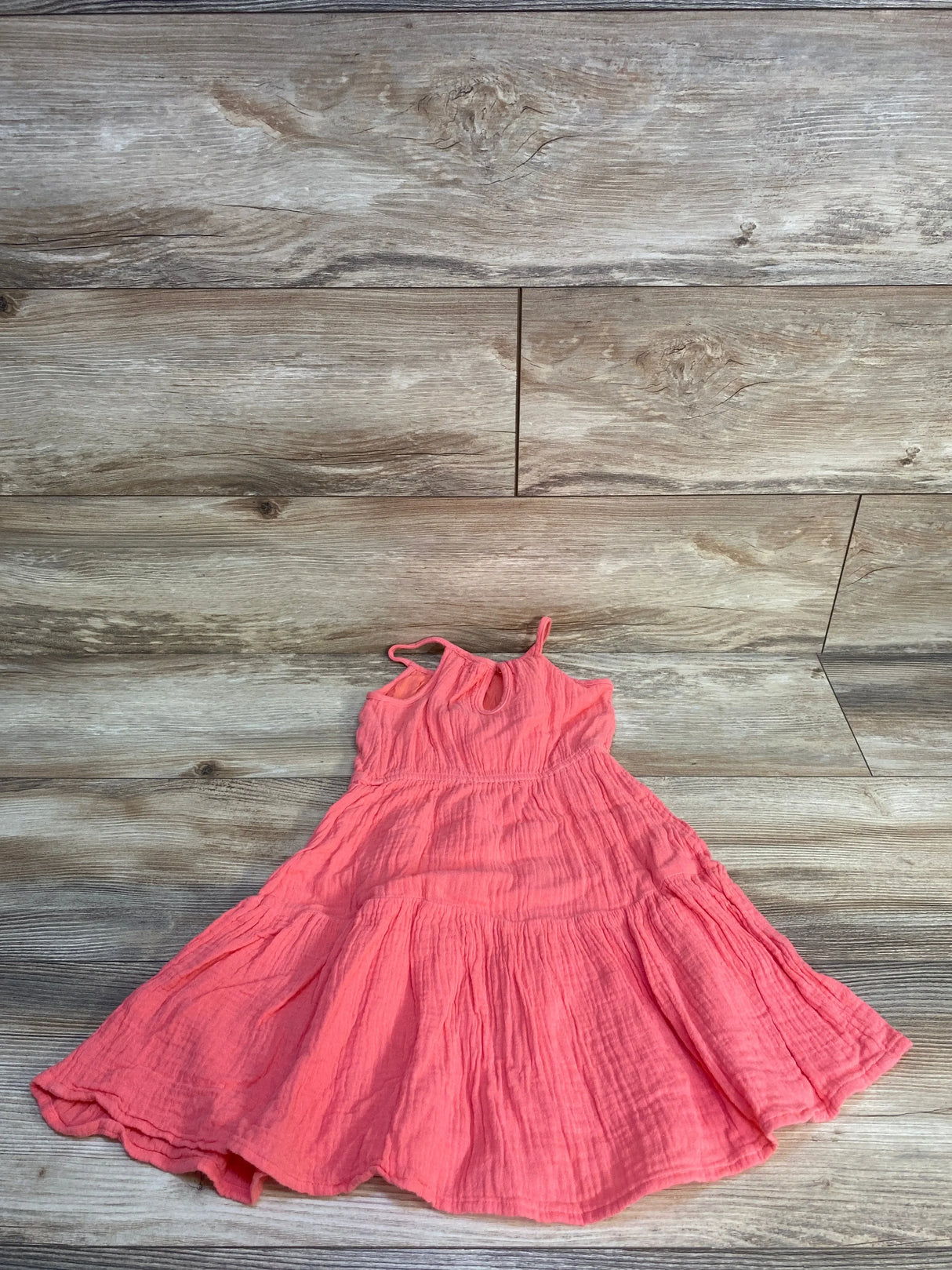 Flat lay of Jumping Beans hot pink gauze toddler dress size 2T showing sleeveless tiered ruffle skirt on wood background