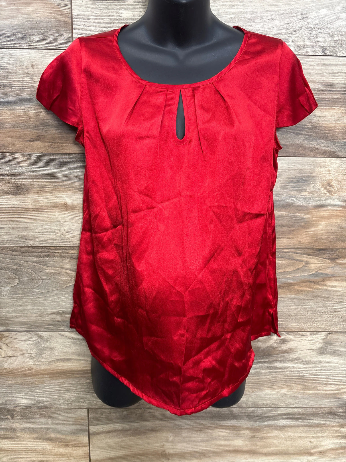 Red satin maternity blouse with short sleeves and keyhole neckline on mannequin