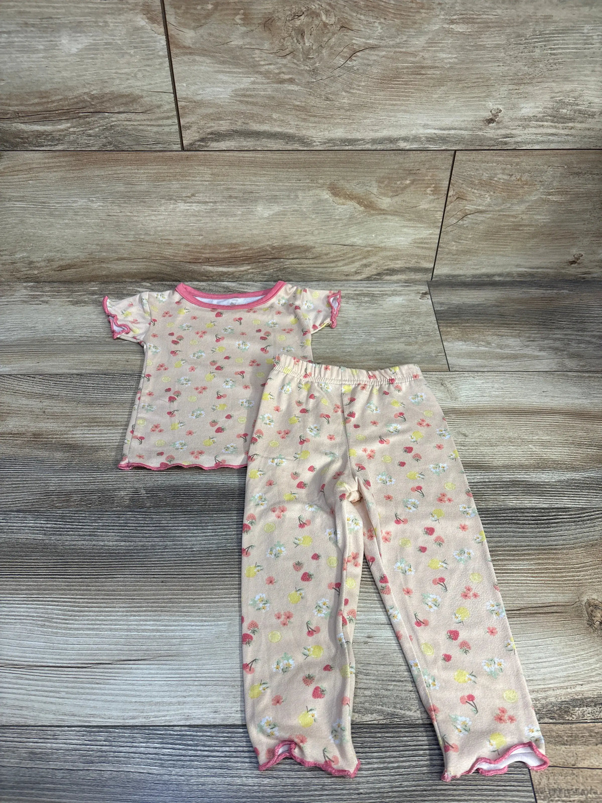 Le Top 2pc pink fruit print pajama set for infants, size 12m, on a wood background